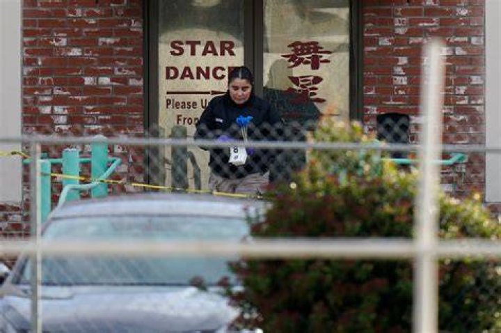 An investigator carries markers outside Star Dance Studio in Monterey Park. Photo / AP