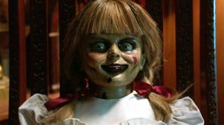 Annabelle the doll smiling in her case.