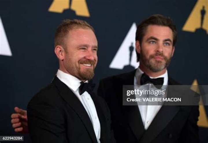 Ben Foster and Chris Pine walking through a field in a poster for Hell or High Water