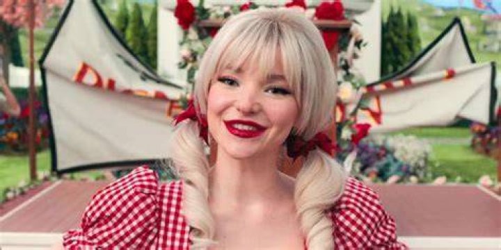Dove Cameron in pigtails, smiling in Schmigadoon season 1
