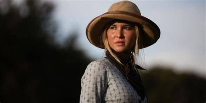 Elsa Dutton (Isabel May) wearing a hat and staring into the sunset in 1883