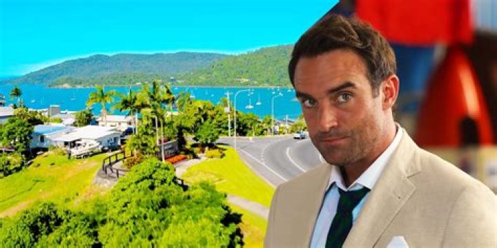 Joshua Sasse as William in Love Is in the Air with a background of the Airlie Beach town