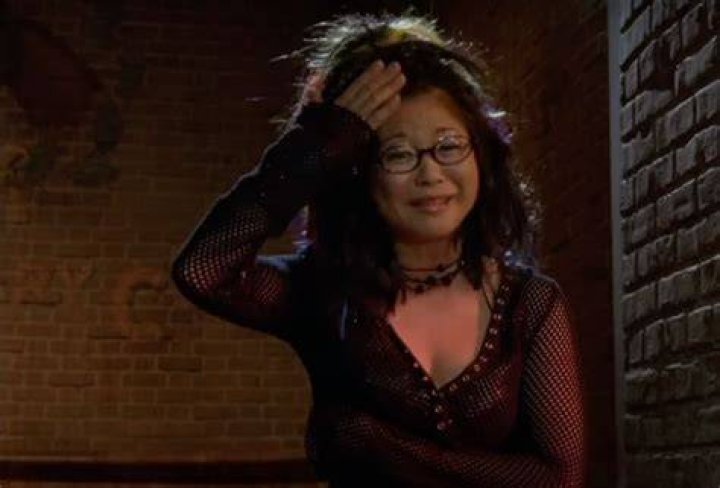 Lane Kim holding a pot of coffee and standing behind the counter at Luke's diner on Gilmore Girls