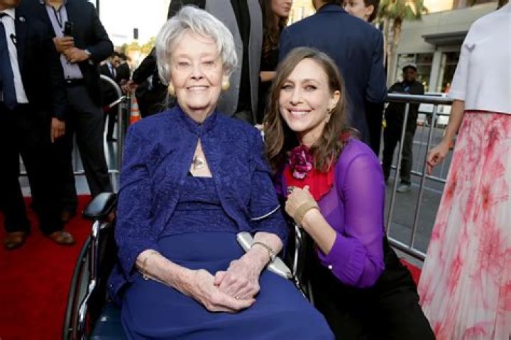 Lorraine Warren stands in the dark with the Nun behind her.