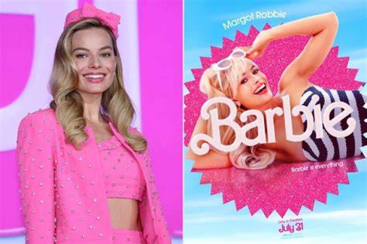 Margot Robbie as Barbie is wearing a pink jumpsuit and smiling.