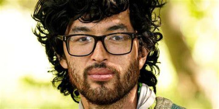 Matt Blankinship Survivor 44 looking serious in glasses yellow background