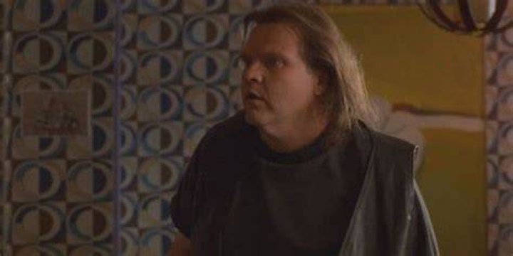 Meat Loaf standing in front of a curtain in The Mighty.