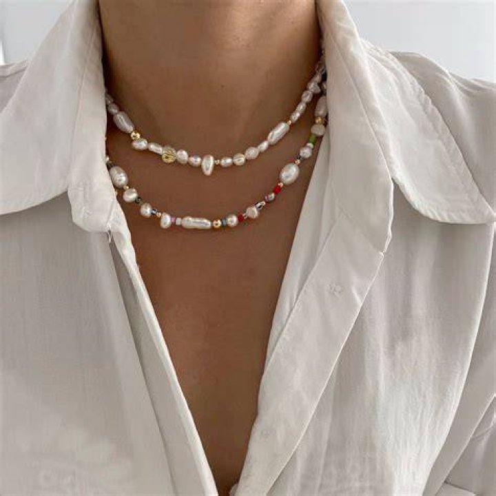 Model wearing beaded necklaces