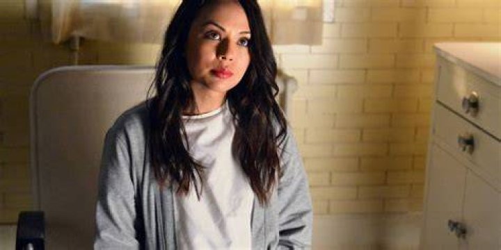 Mona Vanderwaal sitting in a room looking serious on Pretty Little Liars