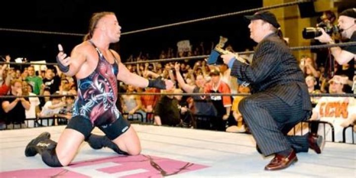 Paul Heyman presenting the WWE Championship to Rob Van Dam. 