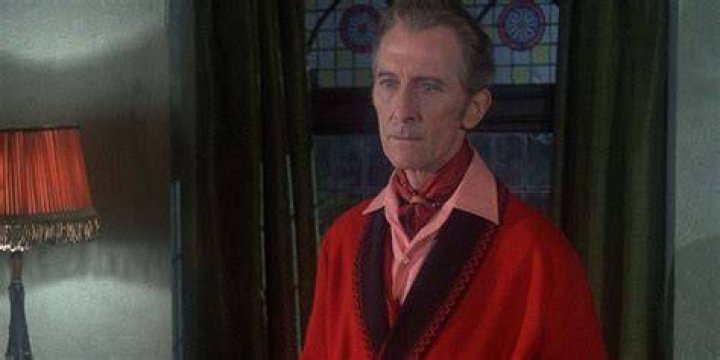 Peter Cushing looks concerned while wearing a red robe in The House That Dripped Blood.