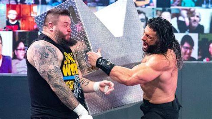 Roman Reigns hits Kevin Owens with a golf cart