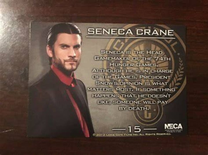 Seneca Crane sitting down in The Hunger Games