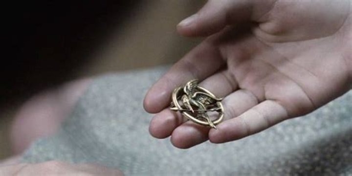 The Mockingjay Pin being handed over to Katniss in The Hunger Games