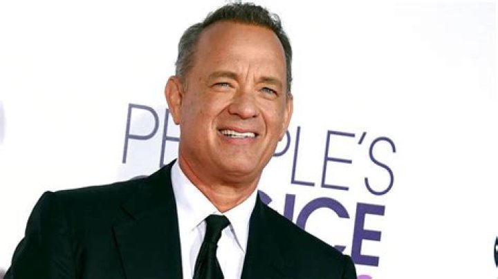 Tom Hanks smiling and holding a cat in A Man Called Otto